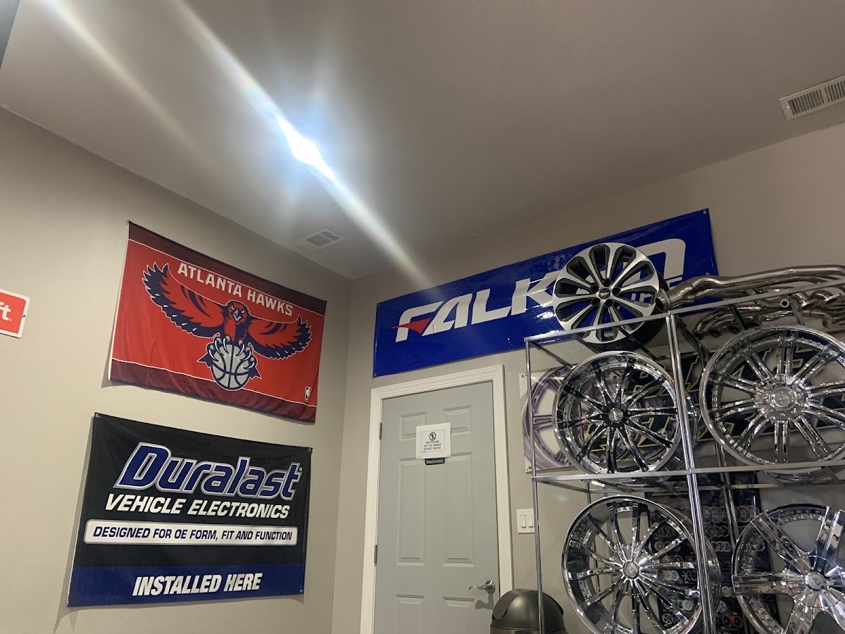 Chrome wheels and tire-brand display inside American Tire Lube & Automotive